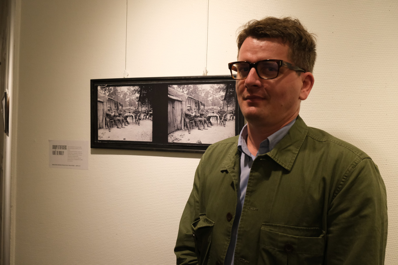 Le professeur d’histoire, Louis Teyssedou, devant la photo d’amis soldats de Raoul Berthelé, attablés avec des charbonniers amiénois. (Aletheia Press / E.Castel)