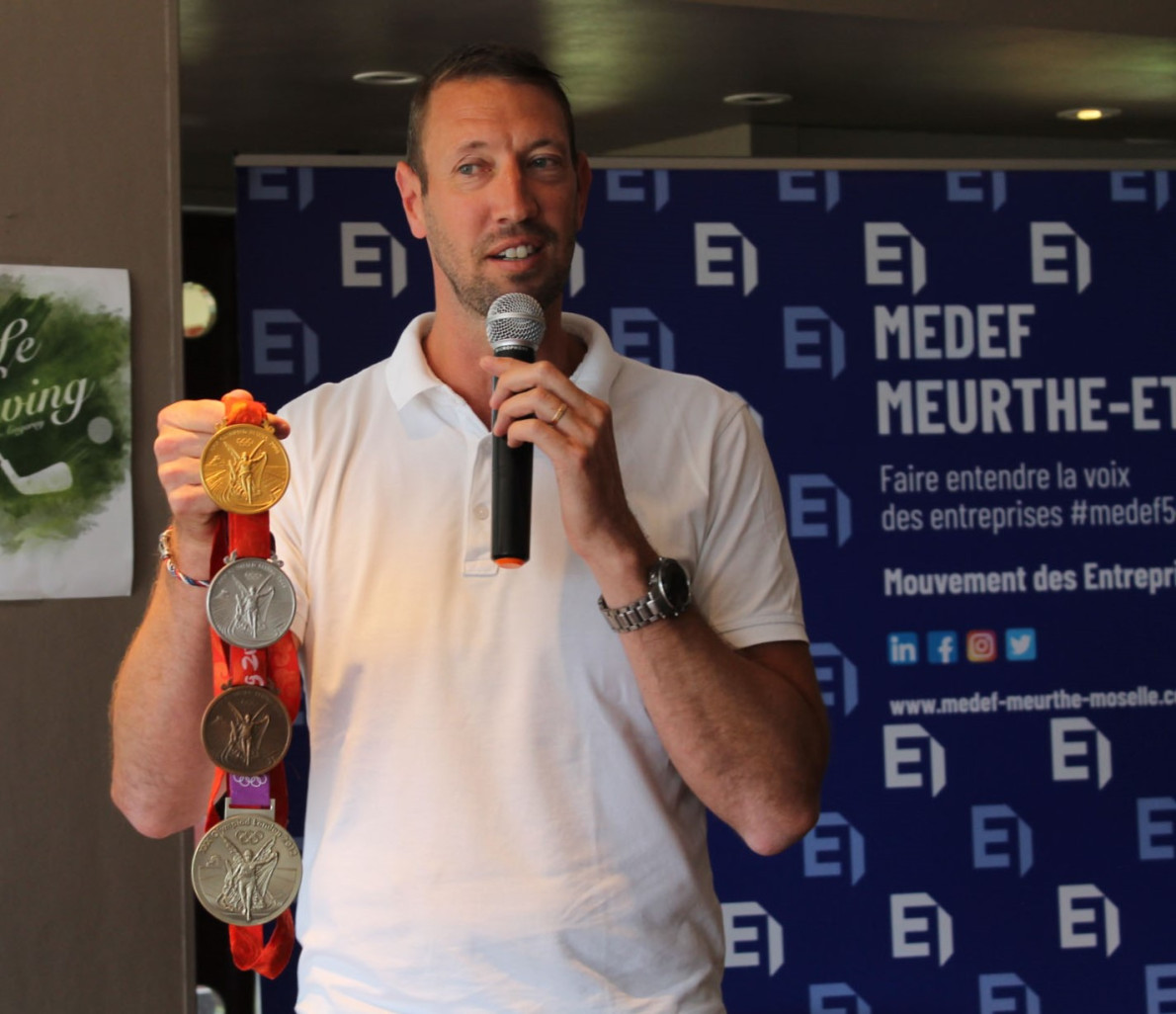 Alain Bernard présentant ses trois médailles gagnées aux Jeux de Pékin en 2008 (une de chaque métal) et sa médaille d’or, en relais, des olympiades de Londres en 2012.