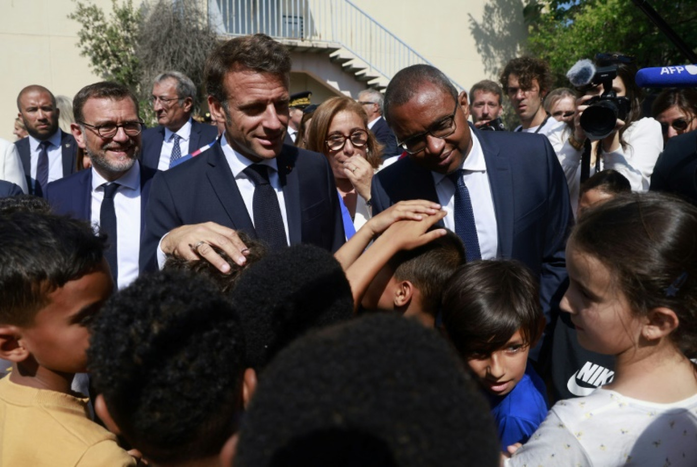 Le président Emmanuel Macron (C) et le ministre de l'Education Pap Ndiaye (D) visitent une école primaire à Marseille le 27 juin 2023 © Guillaume HORCAJUELO