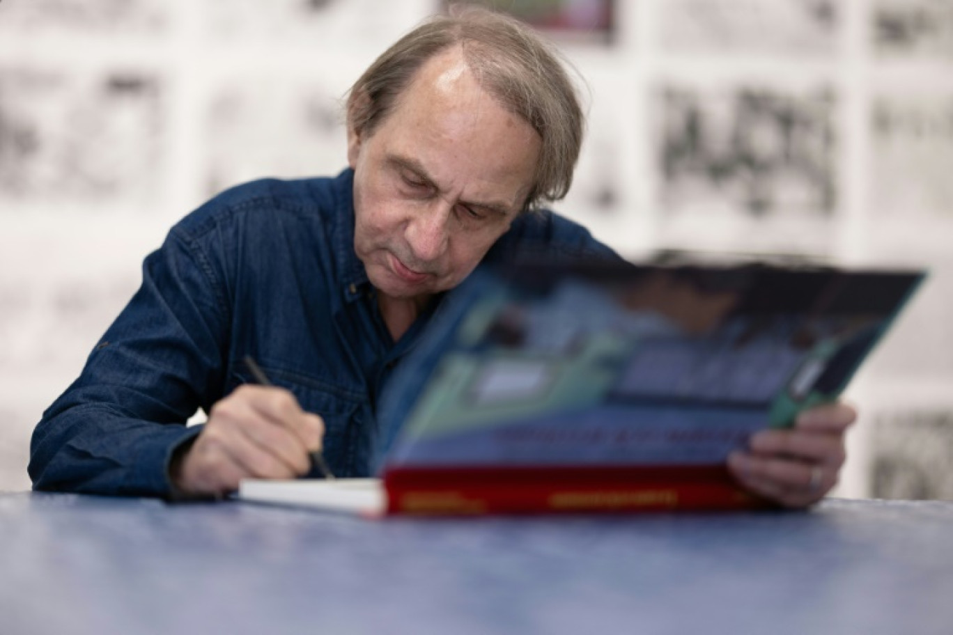 L'écrivain Michel Houellebecq dédicace des exemplaires du roman graphique adapté de "La Carte et le Territoire" et dessiné par Louis Paillard, le 30 juin 2023 à Paris © JOEL SAGET