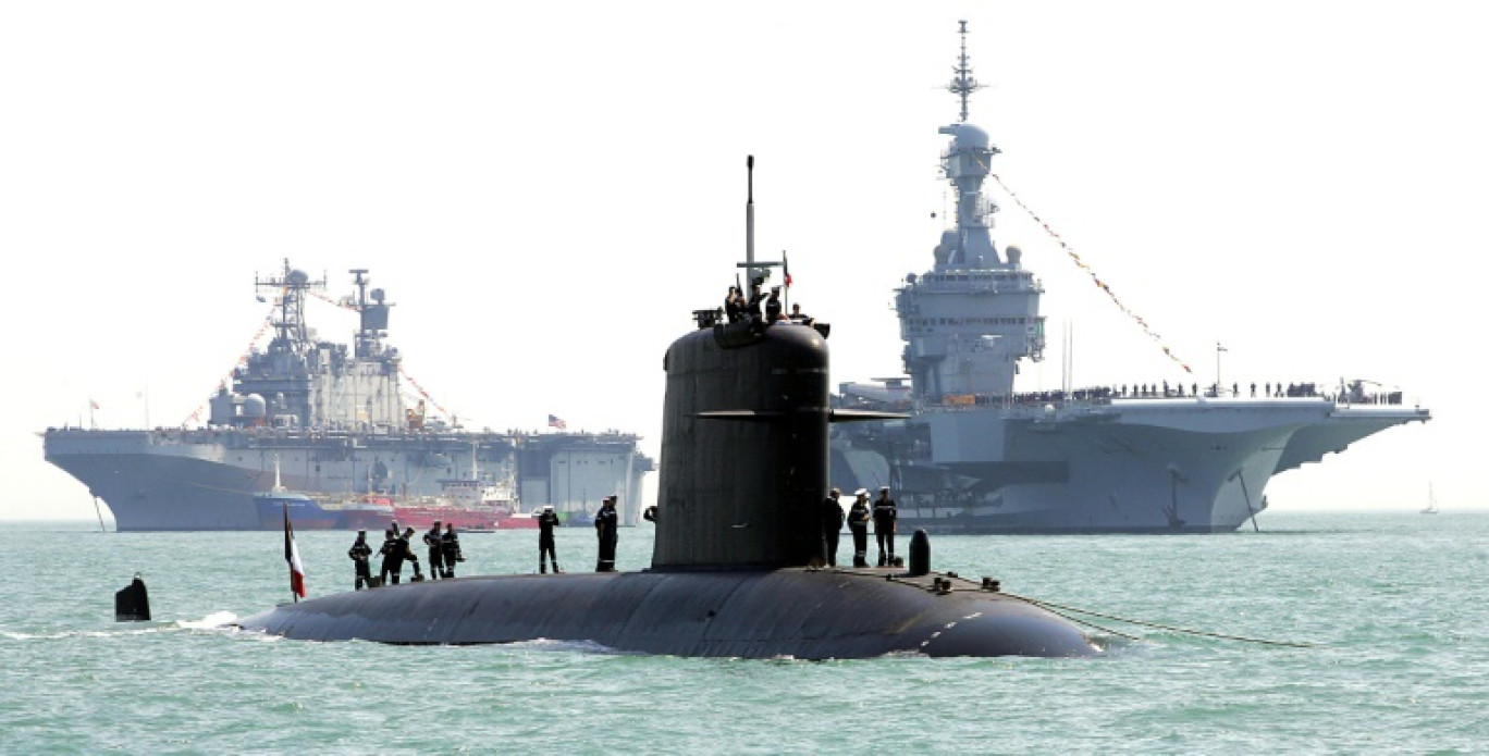 Des marins sortent sur la coque du sous-marin français Perle pour l'inspecter le 27 juin 2005 à Portsmouth, au Royaume-Unis, à la veille d'une reconstitution historique de la bataille de Trafalgar en costumes d'époque © ALESSANDRO ABBONIZIO