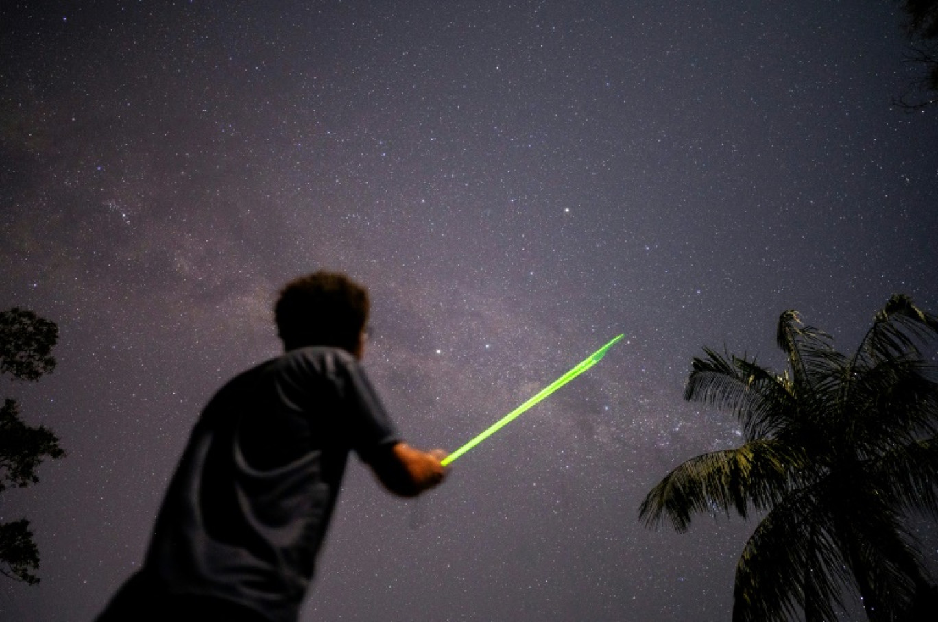 L'astronome Daniel Mello montre les constellations aux visiteurs à l'aide d'un projecteur laser, au Parc du Densengano, le 26 juin 2023, à Santa Maria Madalena, dans l'Etat brésilien de Rio de Janeiro © MAURO PIMENTEL