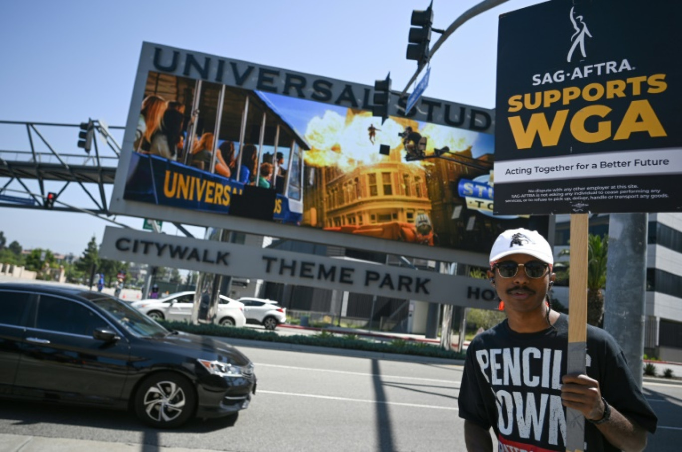 Un membre du syndicat des acteurs SAG-AFTRA défile devant les studios Universal pour soutenir la grève des scénaristes,le 30 juin 2023 à Los Angeles © Robyn Beck