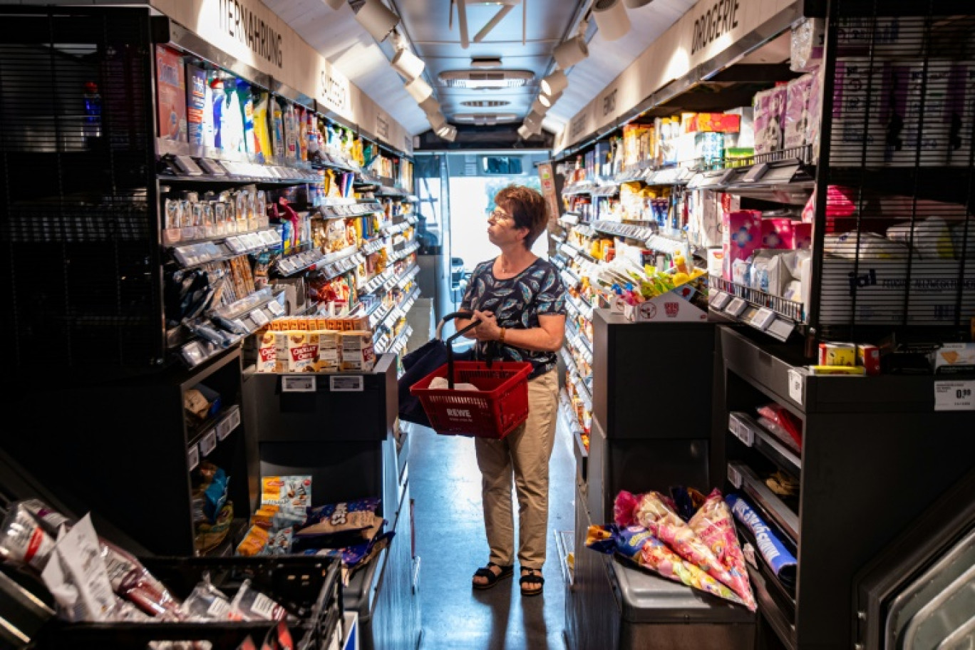 Une cliente fait ses courses dans un bus Rewe aménagé en supermarché, le 6 juillet 2023 lors d'une étape à Lohne, dans le centre de l'Allemagne © ANDRE PAIN