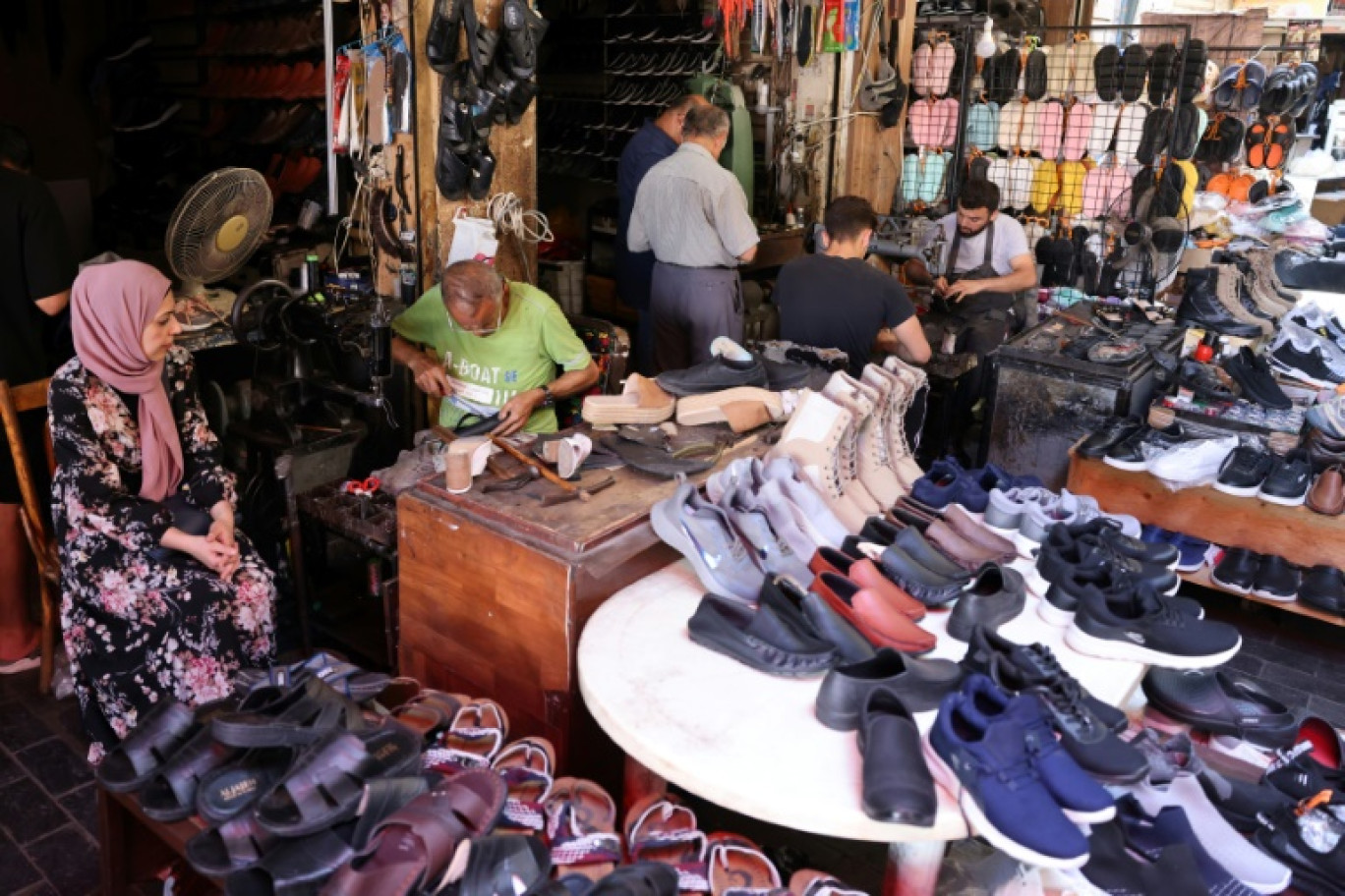 Des ouvriers réparent des chaussures pendant que des clients attendent dans la cordonnerie d'Ahmed al-Bizri, dans la ville côtière de Sidon (Saïda en arabe), au Liban, le 11 juillet 2023 © JOSEPH EID