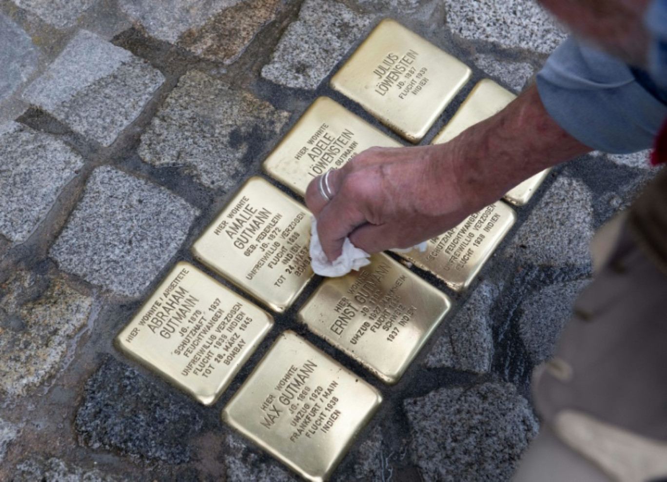 Des "Stolpersteine" sont nettoyées par l'initiateur du projet, l'artiste Gunter Demnig, lors de leur installation, le 30 mai 2023 à Feuchtwangen, en Allemagne © THOMAS KIENZLE