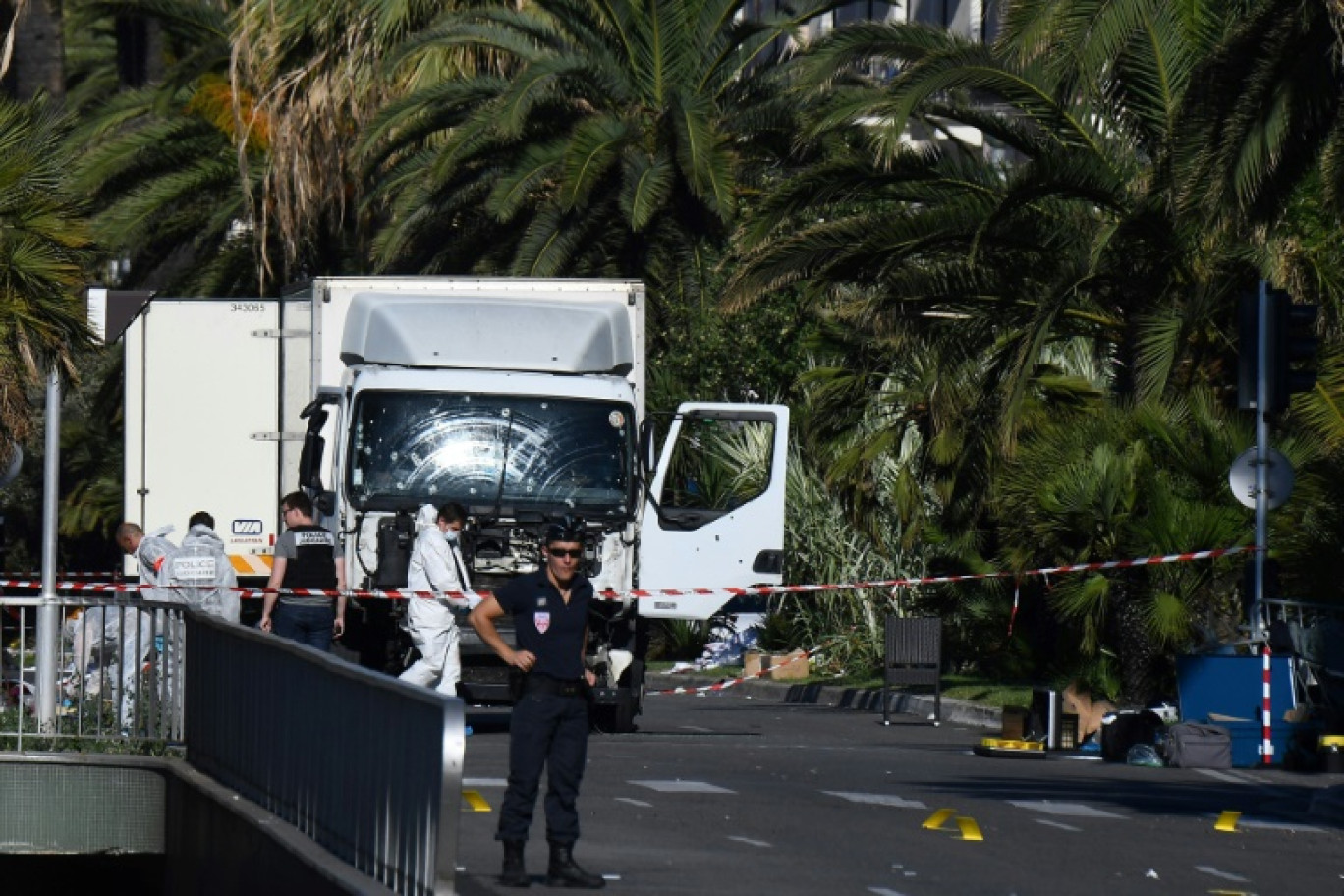 Des policiers près du camion qui a foncé la veille dans la foule sur la Promenade des Anglais à Nice, le 15 juillet 2016 © ANNE-CHRISTINE POUJOULAT