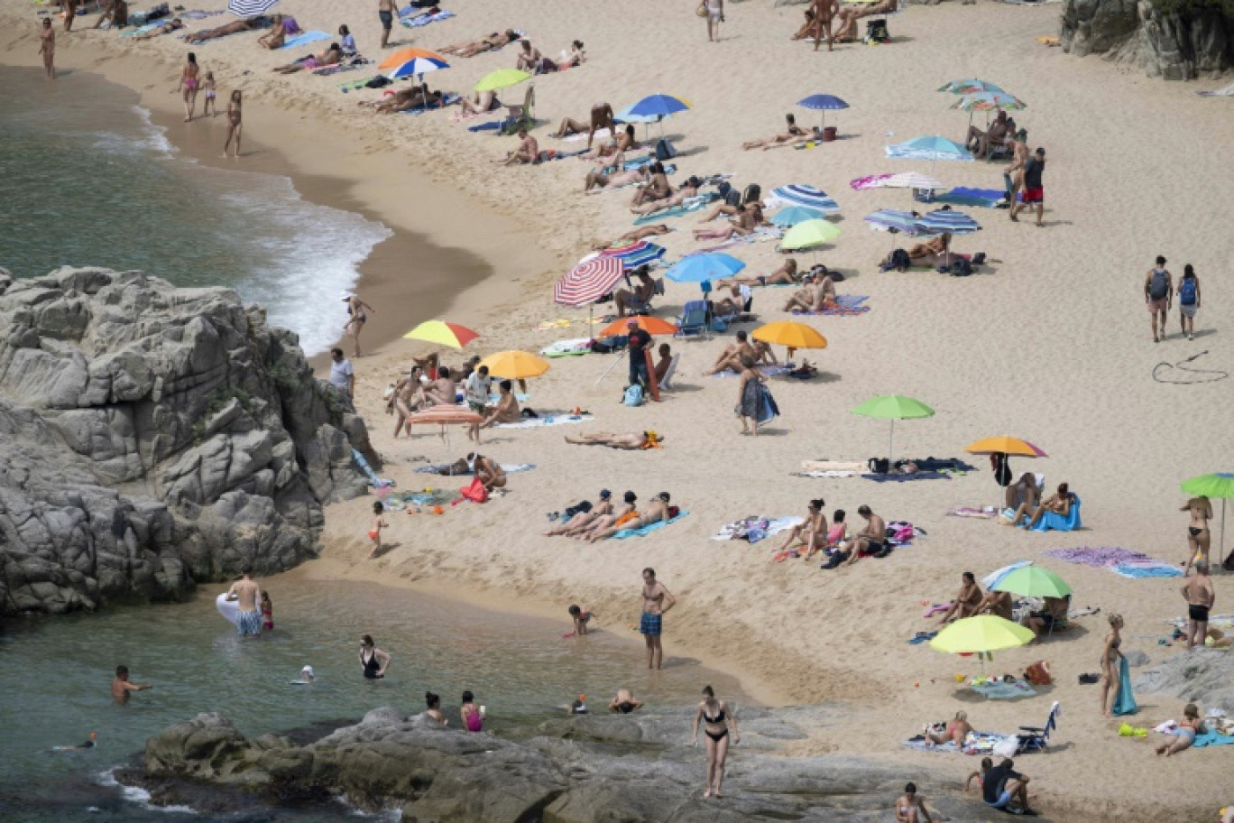 Des touristes prennent un bain de soleil sur l'une des plages de Lloret de Mar, le 29 juin 2023 © Josep LAGO