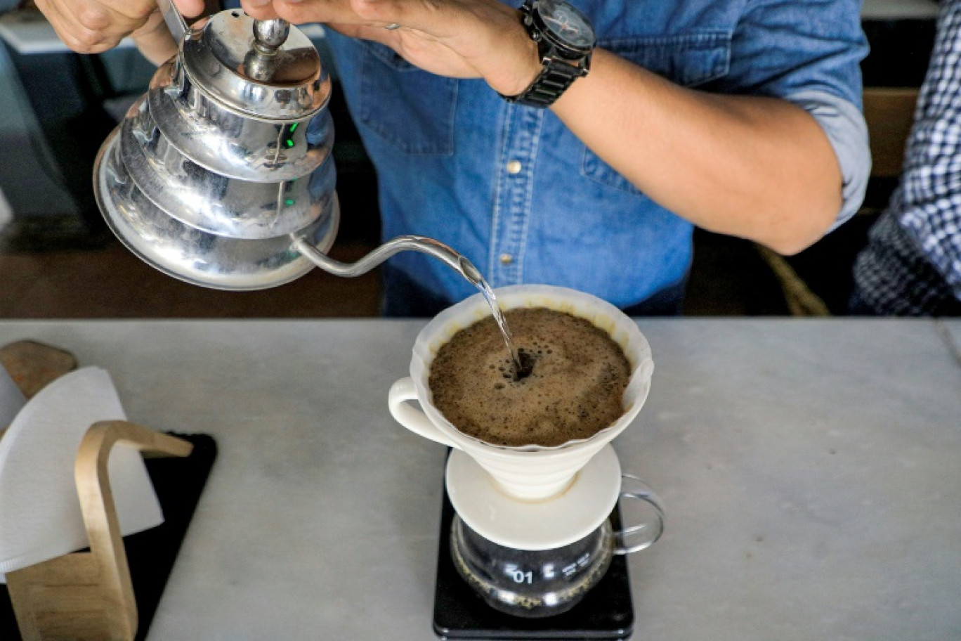 Un homme sert du café dans un café de Sanaa, capitale du Yémen tenue par les Houthis, le 23 juillet 2023 © MOHAMMED HUWAIS