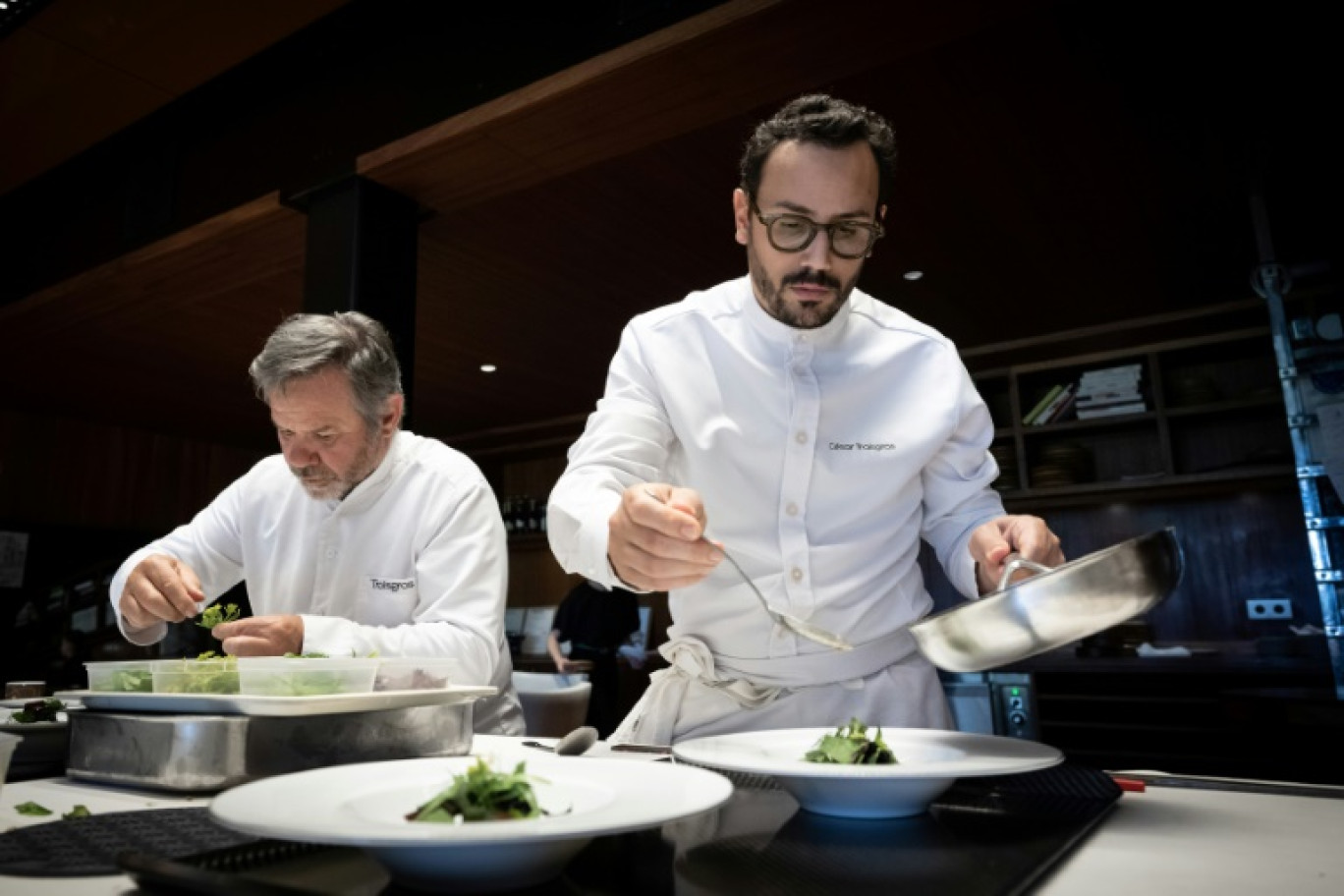 Le chef étoilé César Troisgros (d), et son père Michel Troisgros, dans les cuisines de son hôtel-restaurant "Le Bois sans Feuilles", le 9 juin 2023 à Ouches, dans la Loire © JEAN-PHILIPPE KSIAZEK