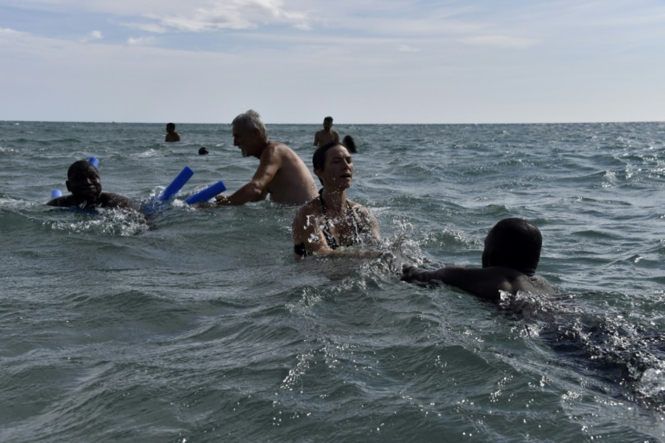 Des membres de l'association "Welcome 66" apprennent à nager à des migrants le 25 juillet 2023 à Canet-en-Roussillon (Pyrénées-Orientales) © RAYMOND ROIG