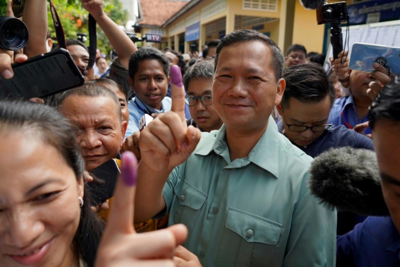 Le général Hun Manet, fils aîné du Premier ministre cambodgien Hun Sen, montre son doigt taché d'encre après avoir voté aux élections législatives, le 23 juillet 2023 à Phnom Penh © -STR