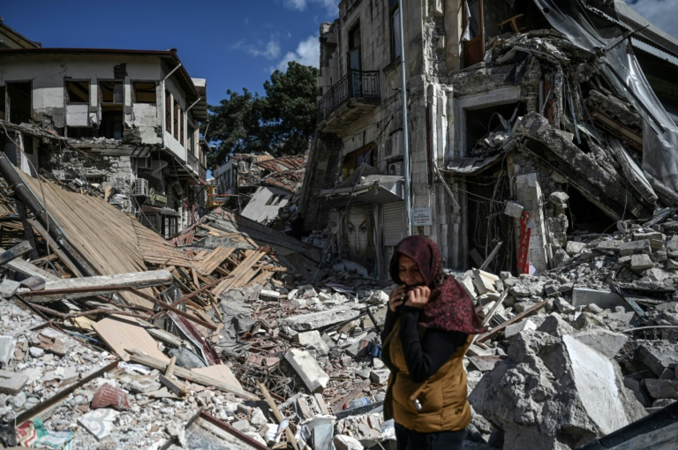 Une femme circule dans les décombres d'immeubles détruits par le séisme du 6 février, à Hatay, en Turquie, le 6 mars 2023 © OZAN KOSE