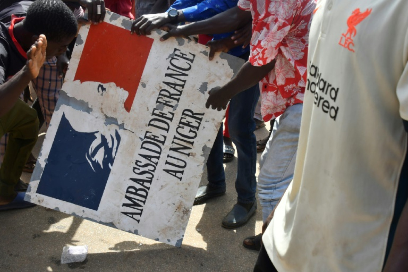 Des manifestants tiennent un panneau de l'ambassade de France après un rassemblement en soutien aux militaires putschistes au Niger, le 30 juillet 2023 à Niamey © -