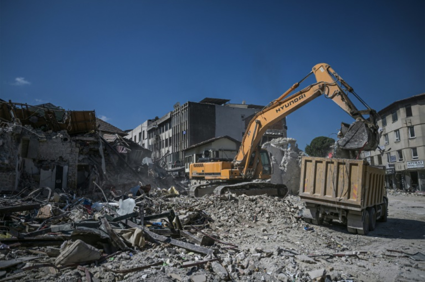 Une pelleteuse déblaie les décombres de bâtiments historiques détruits par le séisme du 6 févier, le 10 juillet 2023 à Antakya, en Turquie © OZAN KOSE