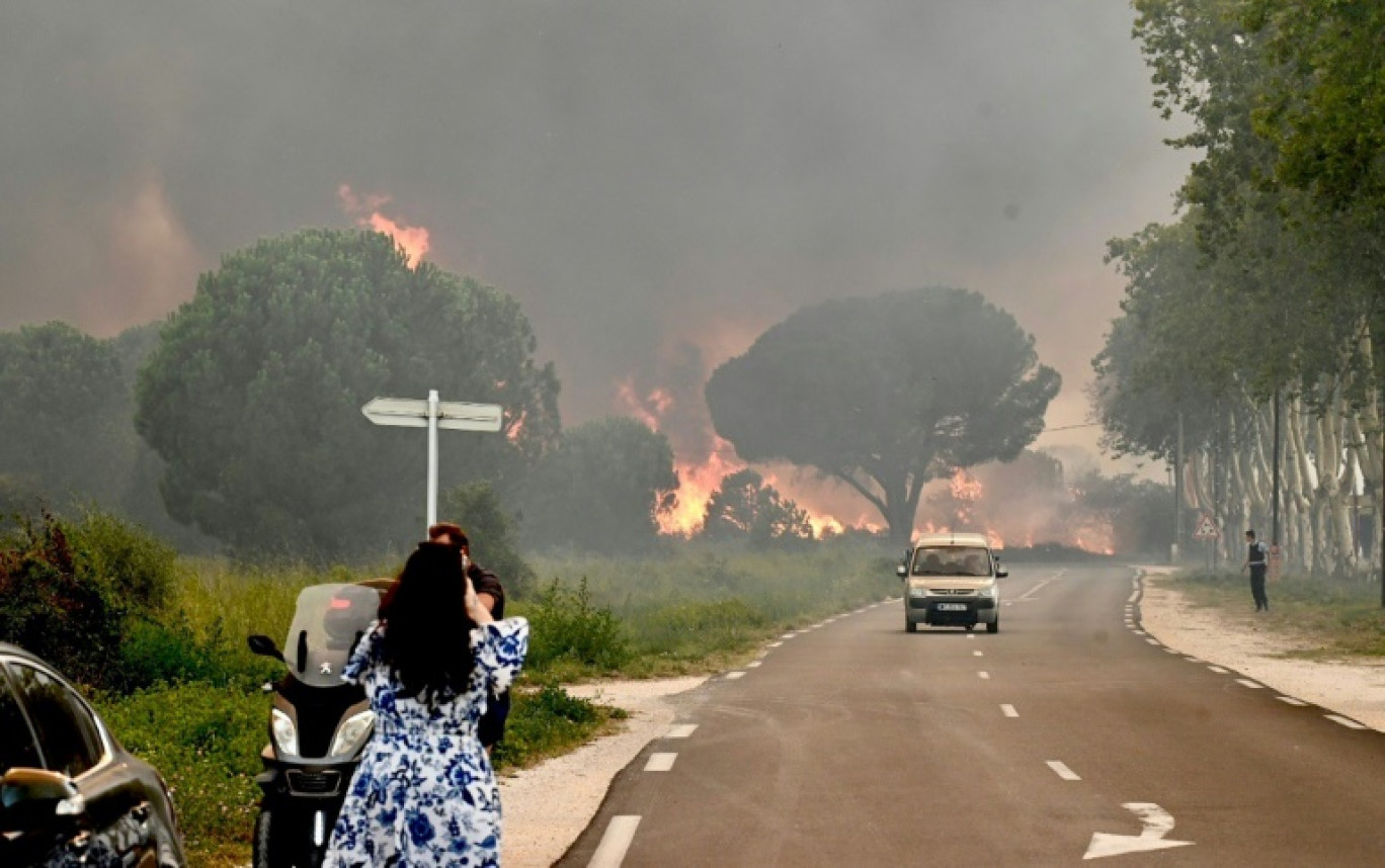 Une femme prend en photo l'incendie qui frappe plusieurs communes des Pyrénées-Orientales, dont Argelès-sur-Mer, le 14 août 2024 © Raymond ROIG