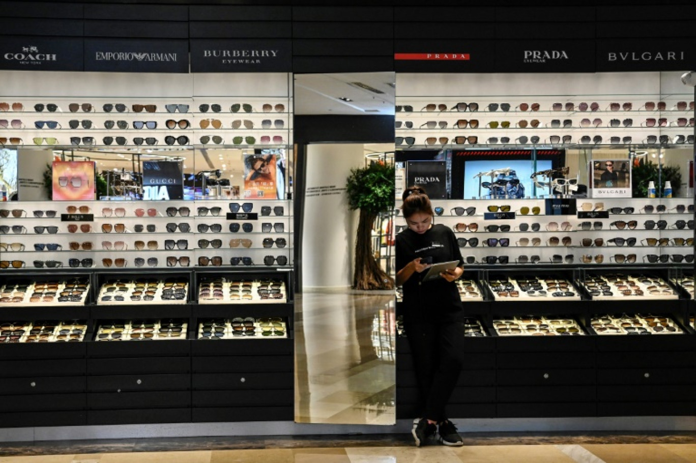 Une vendeuse attend des clients chez un opticien d'un centre commercial à Pékin le 11 août 2023 © Jade Gao