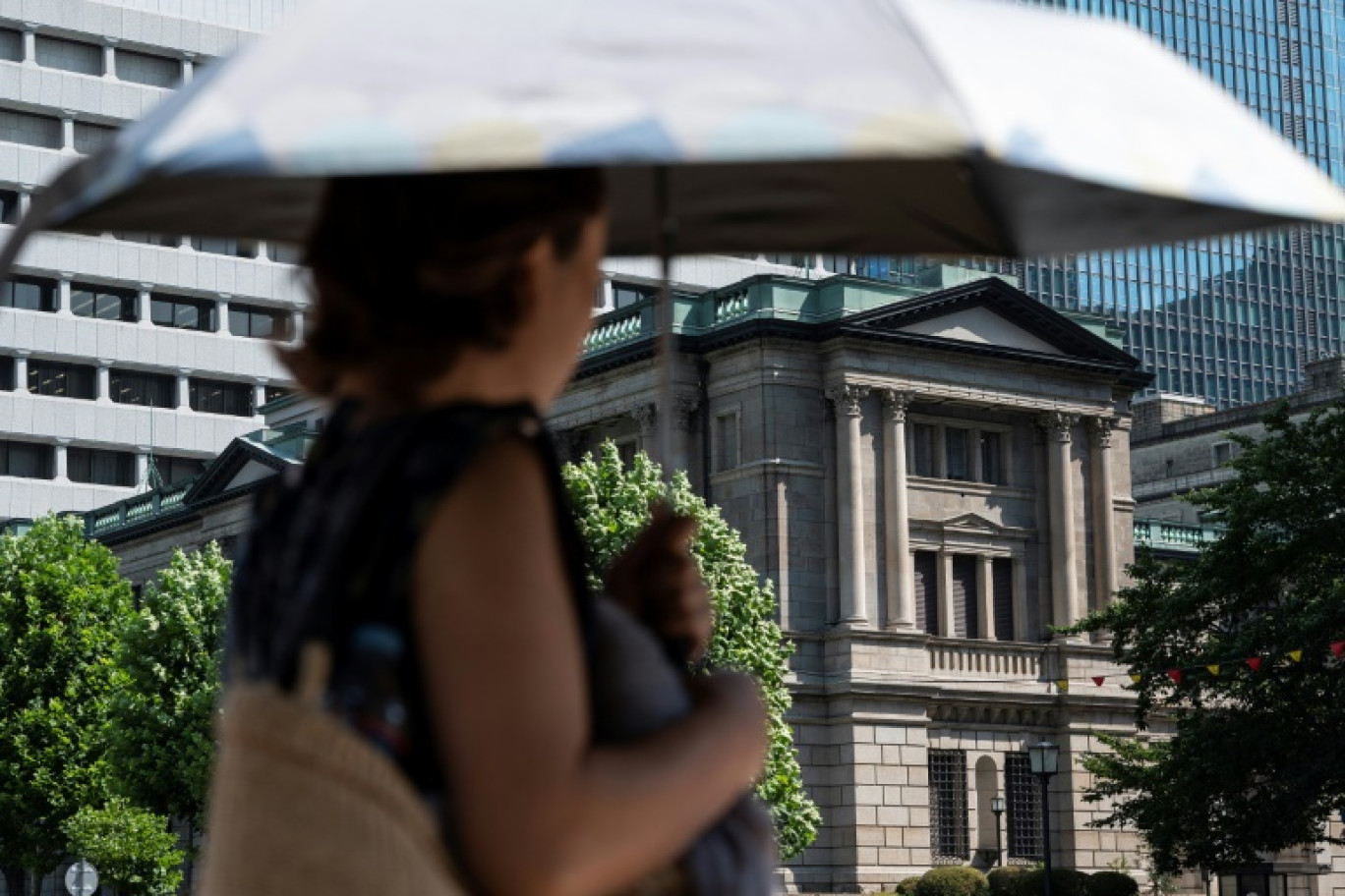 Une passante devant la Banque du Japon (BoJ), dans le centre de Tokyo, le 28 juillet 2023 © Richard A. Brooks