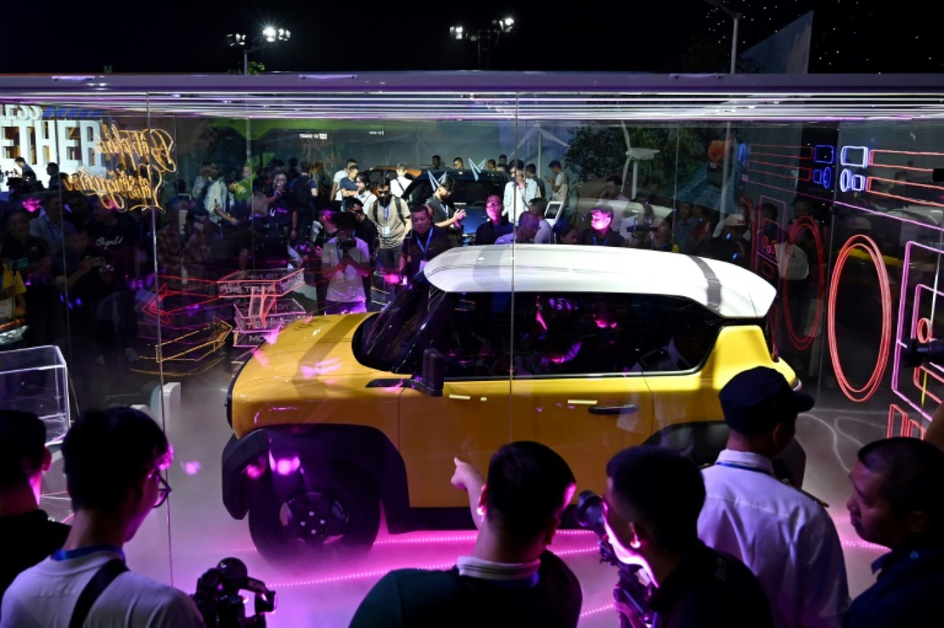 Des gens regardent une voiture électrique lors du lancement de modèles électriques de Vinfast le 7 juillet 2023 à Hanoi © Nhac NGUYEN