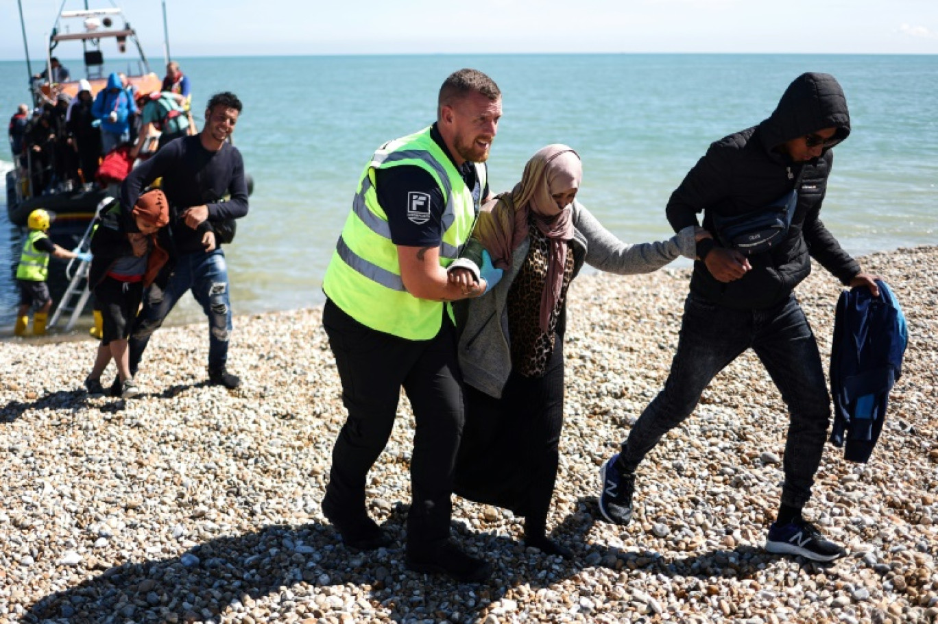 Des migrants, récupérés en mer, arrivent sur la plage de Dungeness, au sud-est de l'Angleterre, le 16 août 2023 © HENRY NICHOLLS