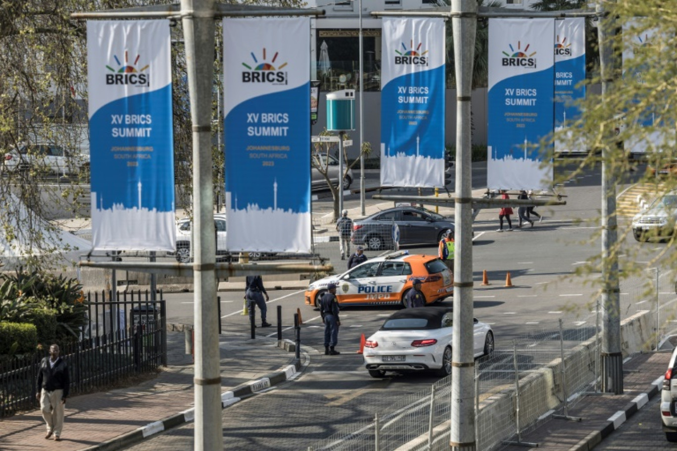 Des véhicules de police devant le Sandton Convention Center avant le sommet des Brics, le 21 août 2023 à Johannesburg, en Afrique du Sud © MARCO LONGARI