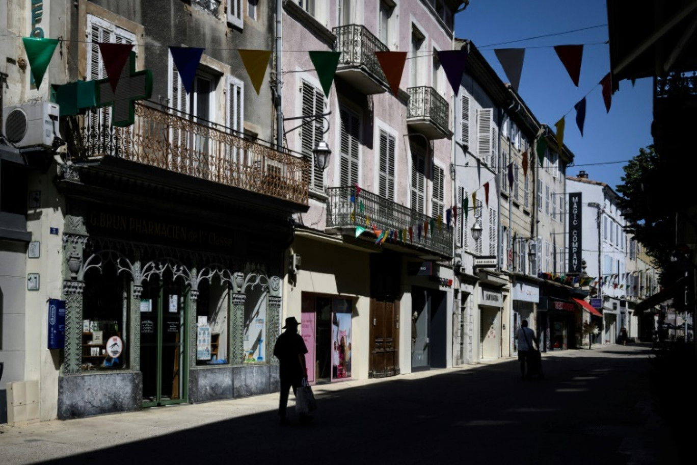 Quelques passants dans une rue de Montélimar pendant un épisode de canicule, le 22 août 2023 dans la Drôme © JEFF PACHOUD