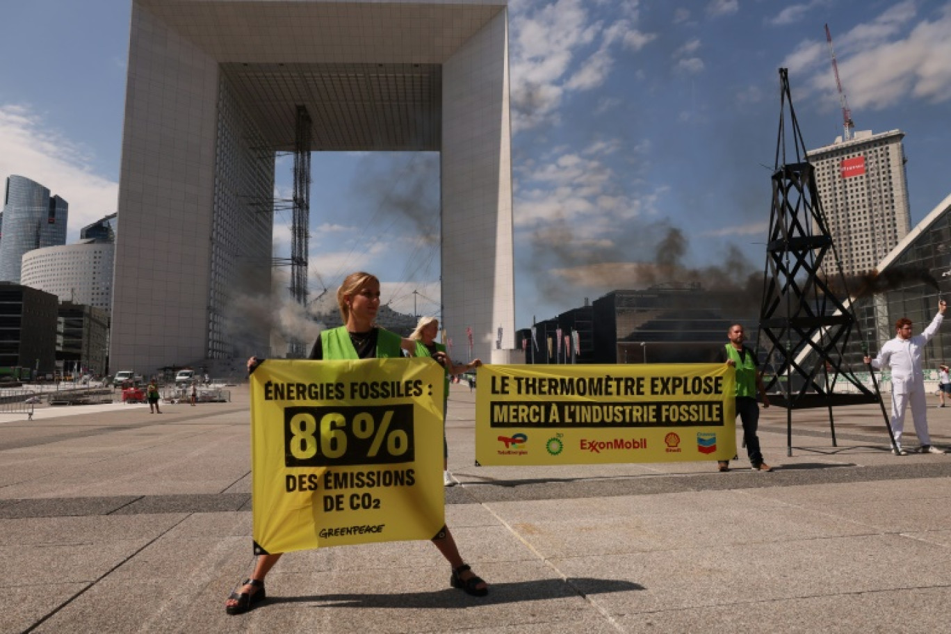 Des membres de Greenpeace manifestent contre l'industrie et les énergies fossiles, le 22 août 2023 à La Défense, près de Paris © Alain JOCARD