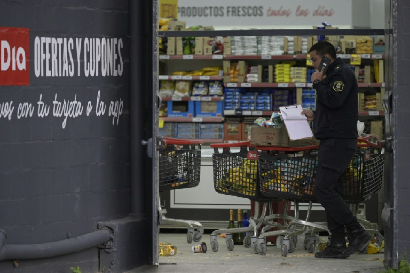 Un policier dans un supermarché pillé, le 22 août 2023 à José C. Paz, faubourg populaire près de Buenos Aires, en Argentine © Juan MABROMATA