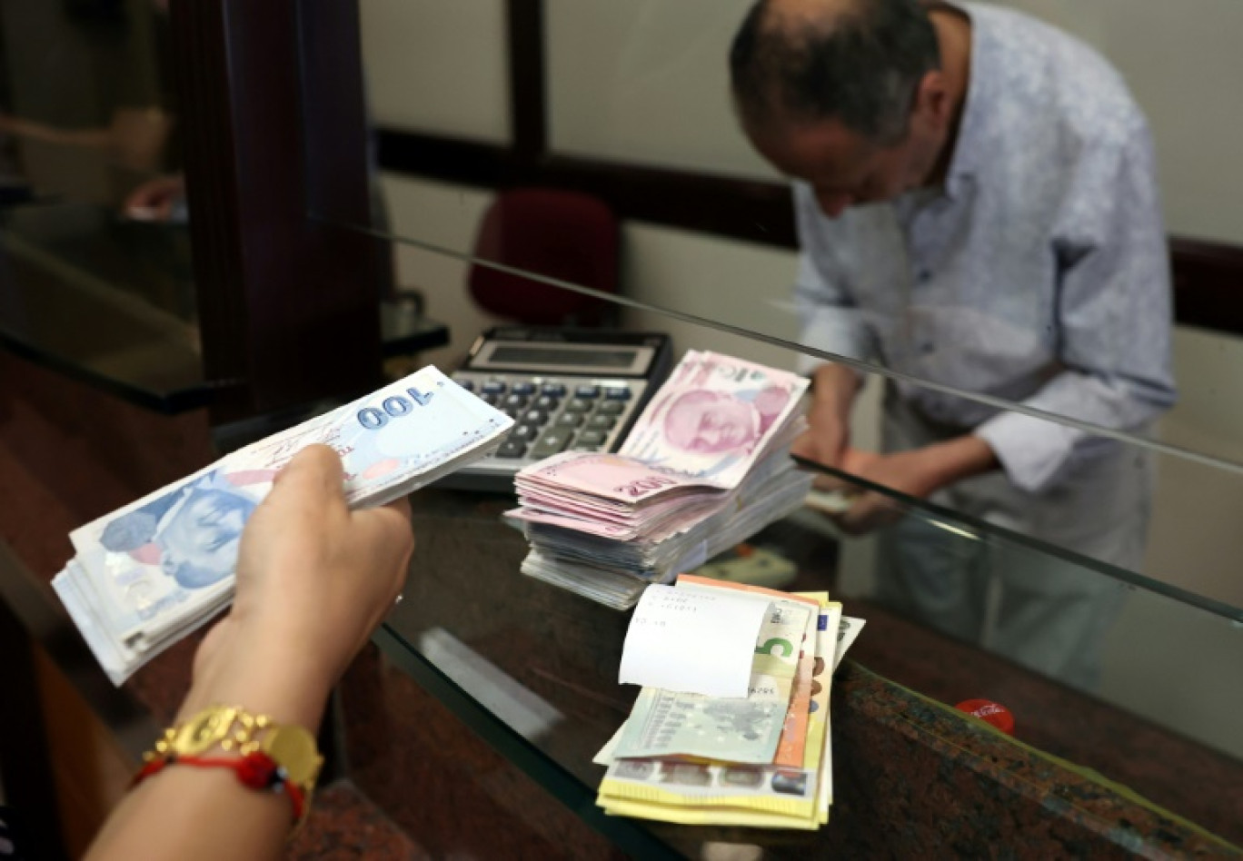 Un client échange des euros contre des livres turques à Ankara, le 20 juillet 2023 © Adem ALTAN