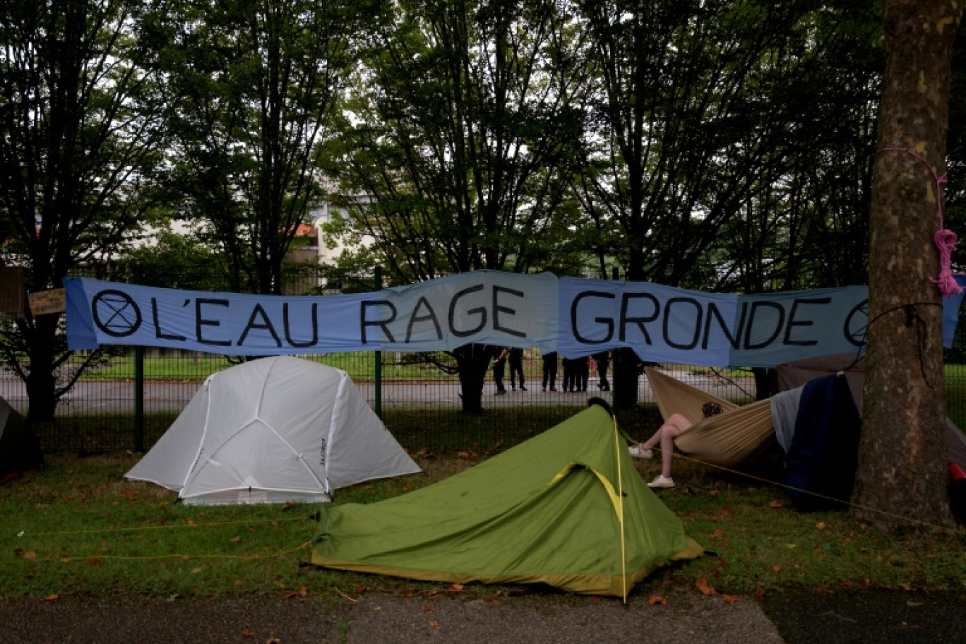 Les participants au Convoi de l'eau campent à Orléans le 25 août 2023, à côté d'une banderole du mouvement Extinction Rebellion © GUILLAUME SOUVANT