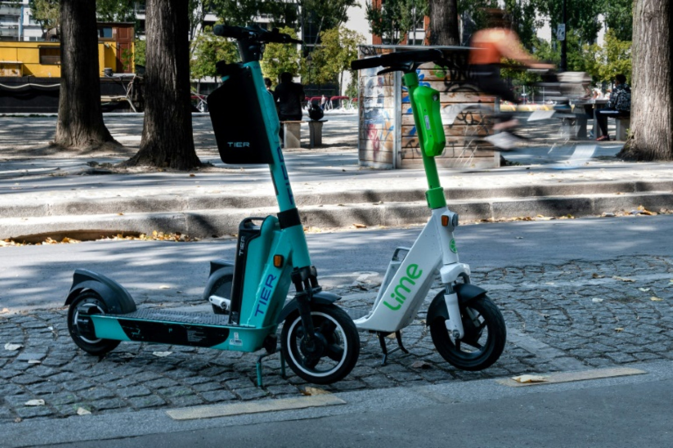 Un employé charge une trottinette électrique dans une camionnette, le 23 août 2023 à Paris © ALAIN JOCARD