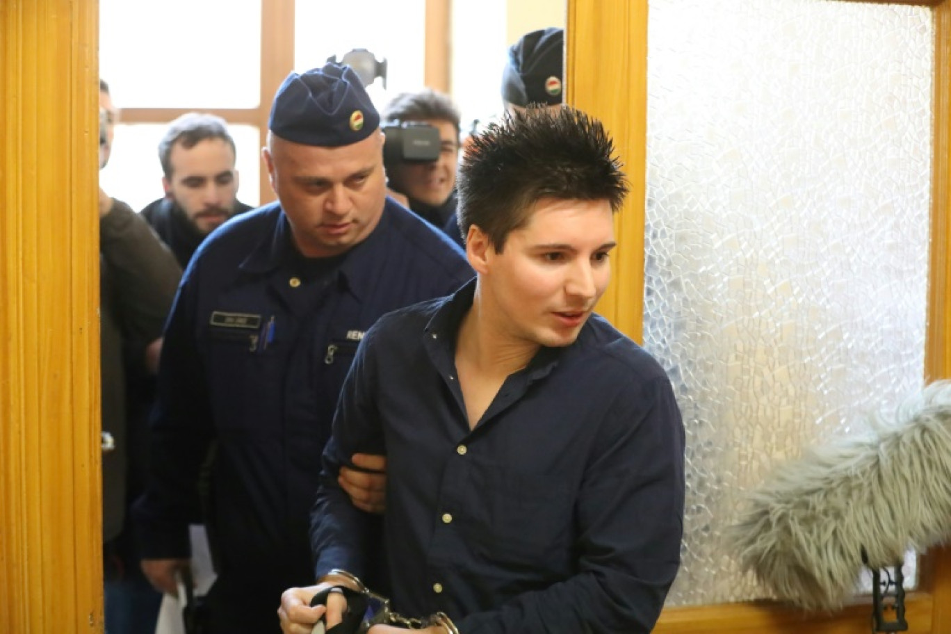 Le Portugais Rui Pinto, principal artisan des "Football Leaks", à son arrivée sous escorte policière au tribunal de Budapest, le 5 mars 2019 © FERENC ISZA