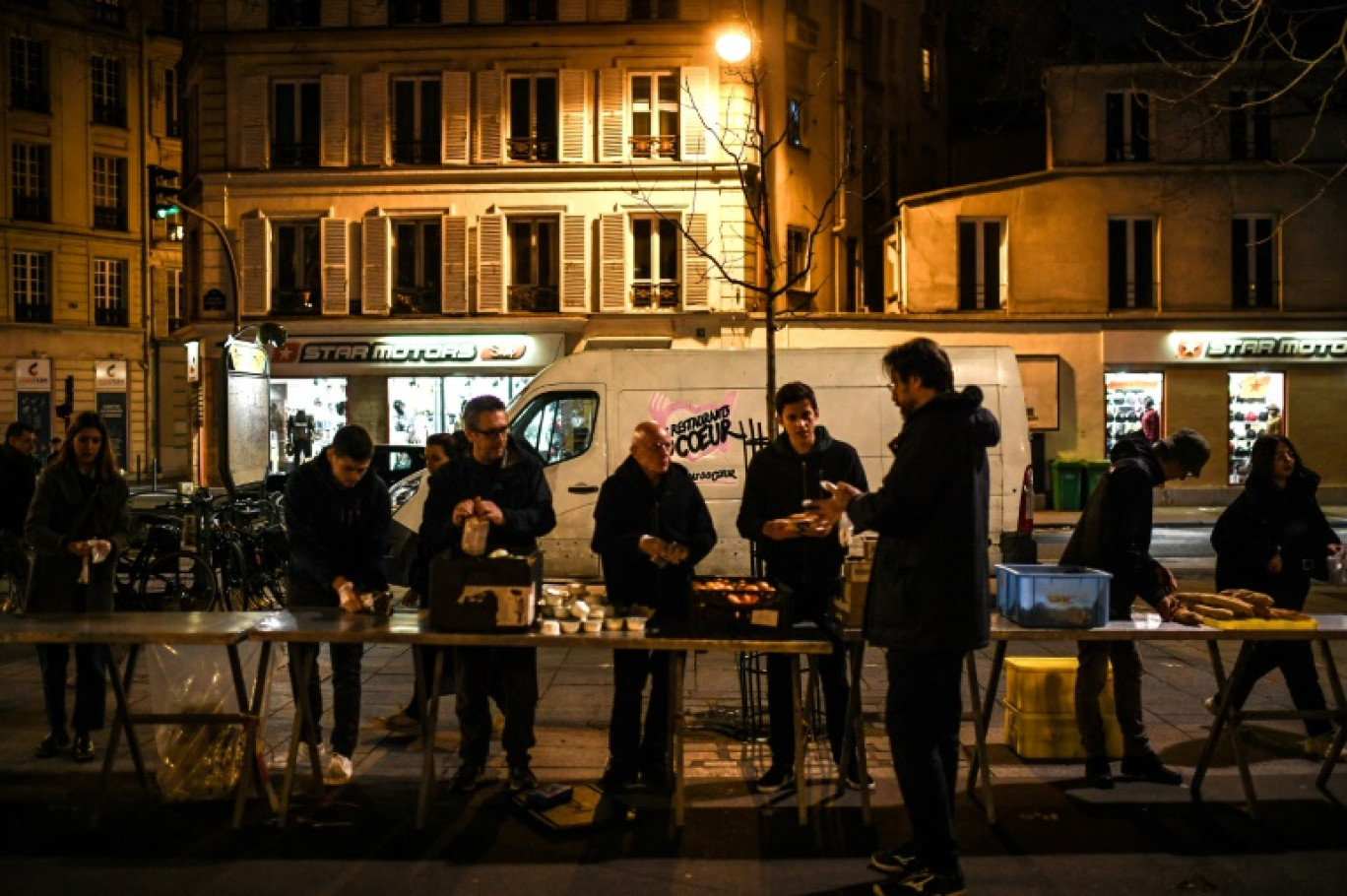 Des bénévoles des "Restos du coeur" mettent en place un point de distribution alimentaire, à Paris le 21 mars 2023 © Christophe ARCHAMBAULT