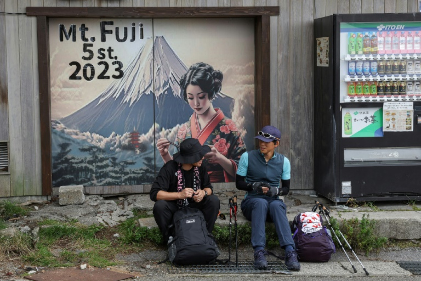 Deux randonneurs se reposent au pied du sentier du mont Fuji, la plus haute montagne japonaise culminant à 3.776 mètres, le 31 août 2023 © Mathias CENA