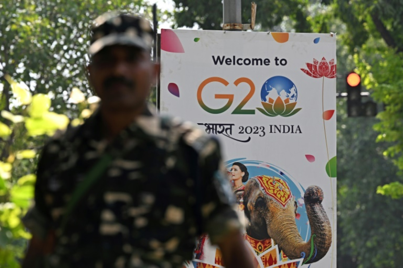 Un agent de sécurité monte la garde à côté d'une pancarte installée dans une rue de New Delhi avant le sommet de deux jours du G20, le 5 septembre 2023 © Sajjad HUSSAIN