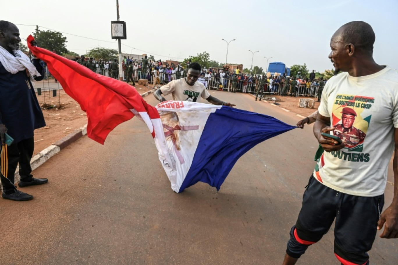 Des partisans des militaires au pouvoir au Niger piétinent le drapeau français lors d'une manifestation à Niamey le 1er septembre 2023 © -