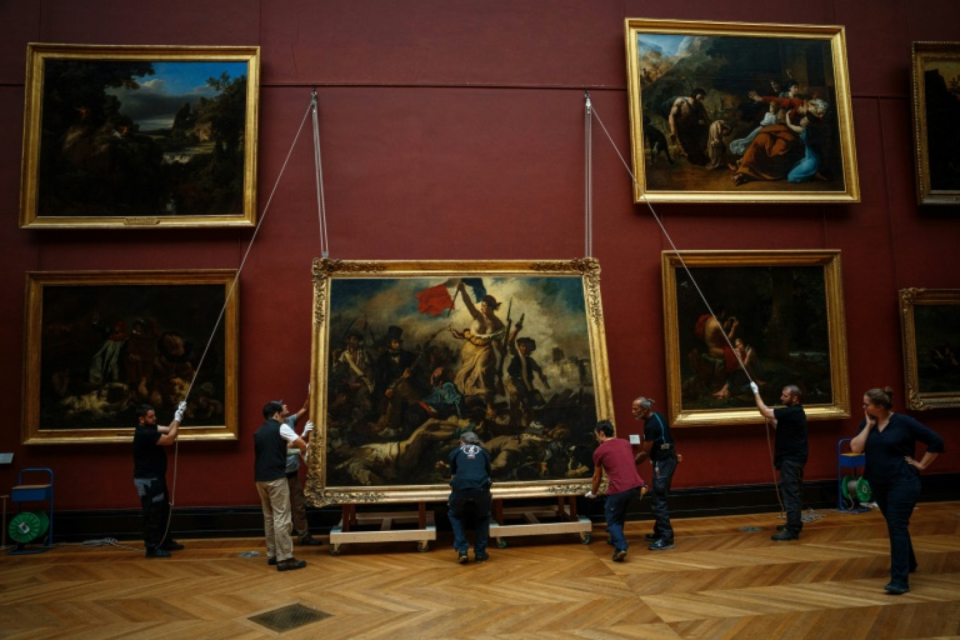 "La liberté guidant le peuple" de Delacroix a été décroché avec d'infinies précautions de ses cimaises au musée du Louvre, le 20 septembre 2023 à Paris, pour une restauration qui doit durer jusqu'au printemps 2024 © Dimitar DILKOFF