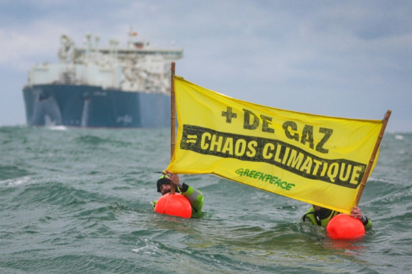 Des militants de Greenpeace France déploient une banderole près du méthanier de TotalEnergies Cape Ann qui s'apprête à entrer dans le port du Havre, le 18 septembre 2023 © Lou Benoist