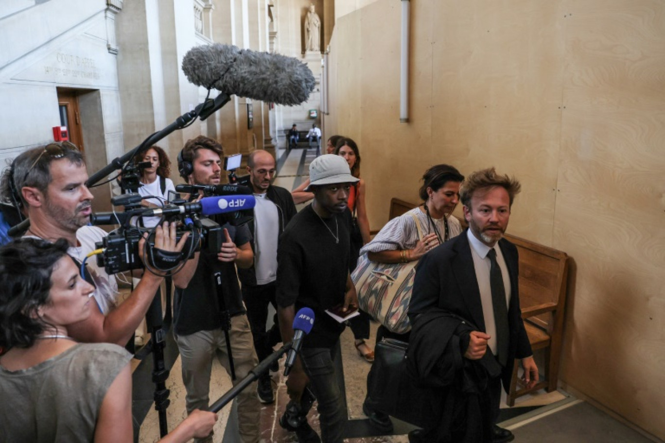 Le rappeur français Mohamed Sylla (C), alias MHD, arrive au palais de justice de Paris le 4 septembre 2023 avec ses avocats Antoine Vey (D) et  Elise Arfi (2e D) pour le début de son procès aux assises © Alain JOCARD