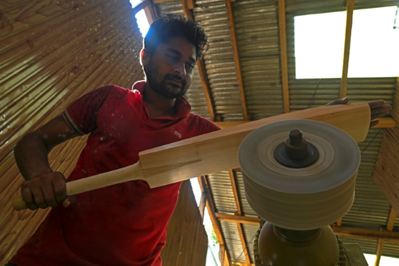 Un artisan fabrique une batte de cricket dans du bois de saule du Cachemire, le 19 août 2023 à Sangam, en Inde © Tauseef MUSTAFA