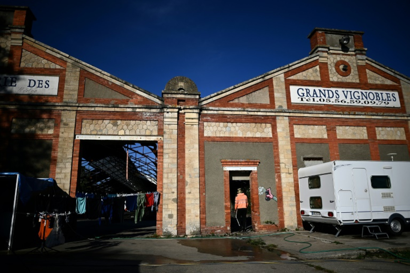 Un campement de travailleurs saisonniers devant un entrepôt à Pauillac, lors des vendanges dans la région du Médoc, le 6 octobre 2023 en Gironde © Christophe ARCHAMBAULT