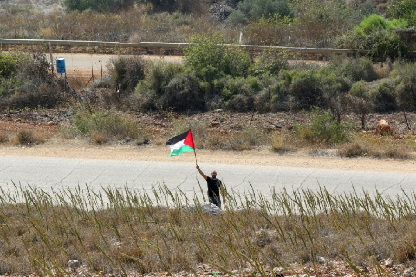 Un Libanais solidaire avec le peuple palestinien près d'un point frontière dans la plaine de Khiyam au Liban, en face de la ville de Metula, au nord d'Israël, le 9 octobre 2023 © Mahmoud ZAYYAT