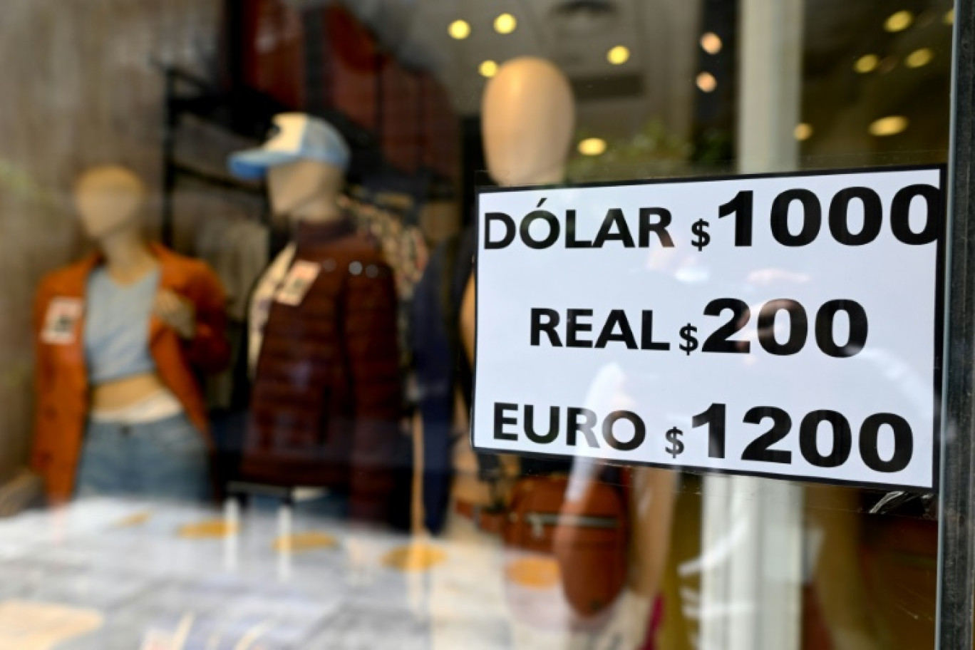 Un panneau avec les valeurs de change du soi-disant « dollar bleu » non officiel du marché parallèle est affiché dans la vitrine d'un magasin à Buenos Aires le 10 octobre 2023 © Luis ROBAYO