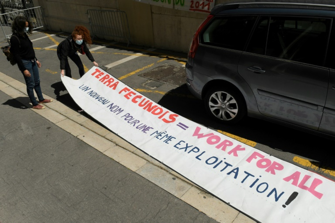 Des manifestants installent une banderole à Marseille le 17 mai 2021 devant le tribunal de commerce au premier jour du procès de la société espagnole Terra Fecundis pour violation des règles du travail détaché © Nicolas TUCAT