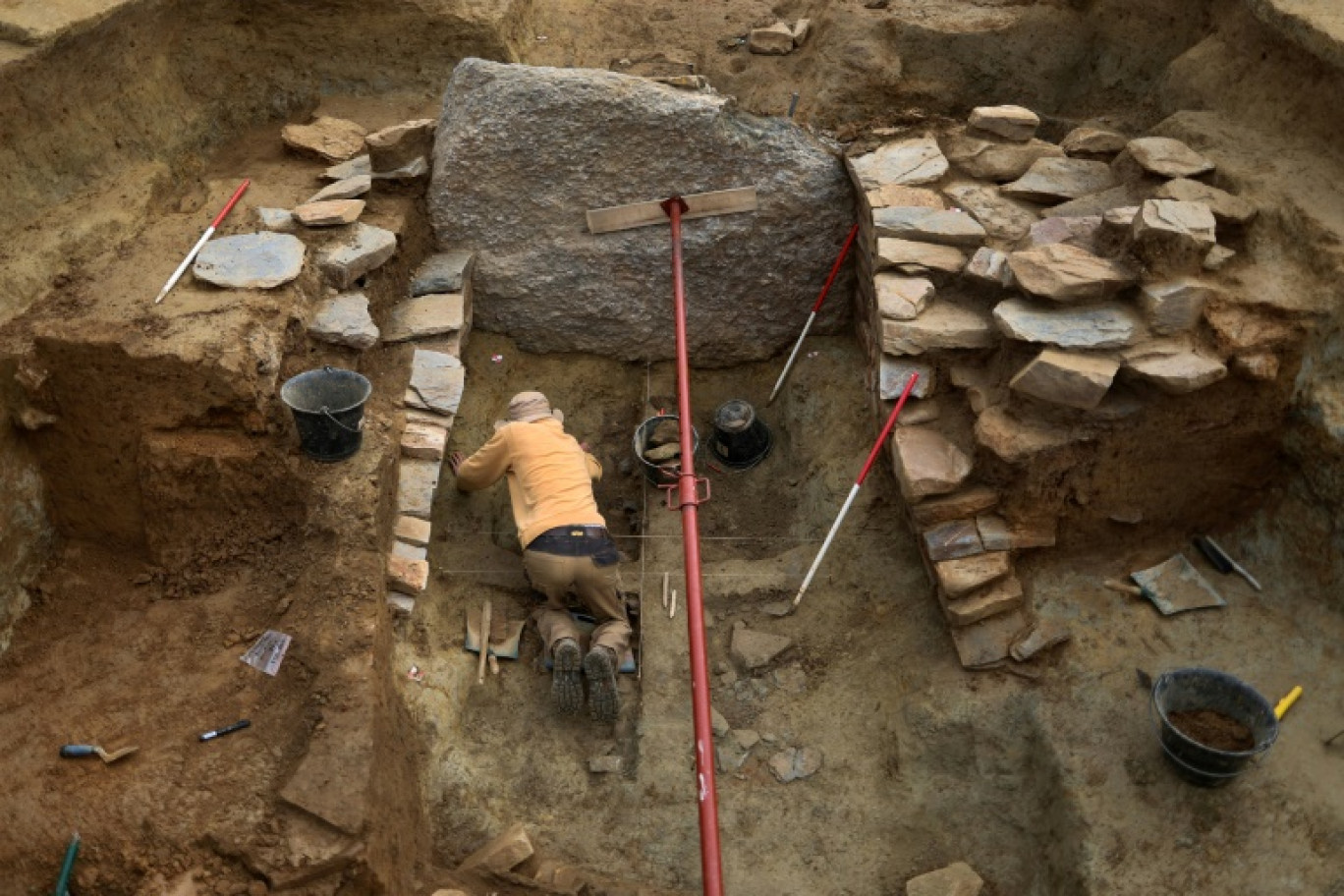 Un étudiant en archéologie sur le chantier de fouilles du tumulus de Saint-Bélec, à Leuhan, dans le Finistère, le 11 octobre 2023 © Fred TANNEAU