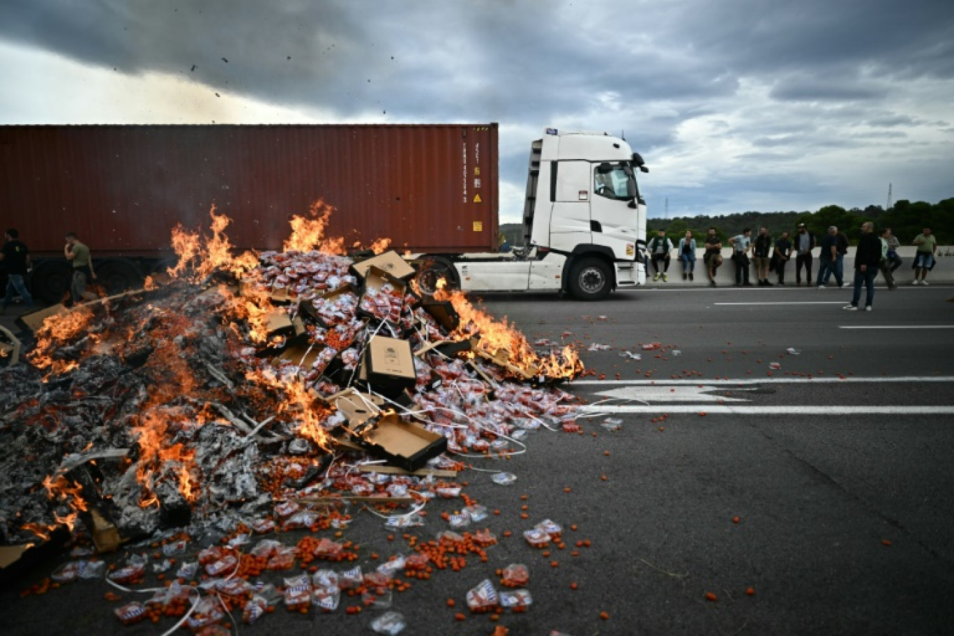 Des viticulteurs vident la cargaison de vin d'un camion lors d'un barrage filtrant au péage du Boulou pour protester contre les importations de vin espagnol, le 19 octobre 2023 dans les Pyrénées-Orientales © LIONEL BONAVENTURE