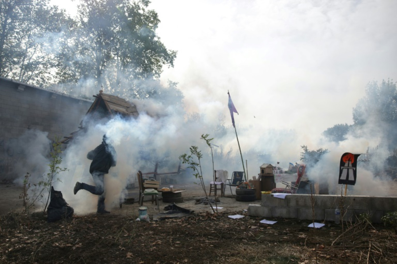 Un militant court dans la fumée de gaz lacrymogènes lors de l'évacuation par les forces de l'ordre de la ZAD installée à Saix contre le projet d'autoroute A69 entre Toulouse et Castres, le 22 octobre 2023 dans le Tarn © Valentine CHAPUIS