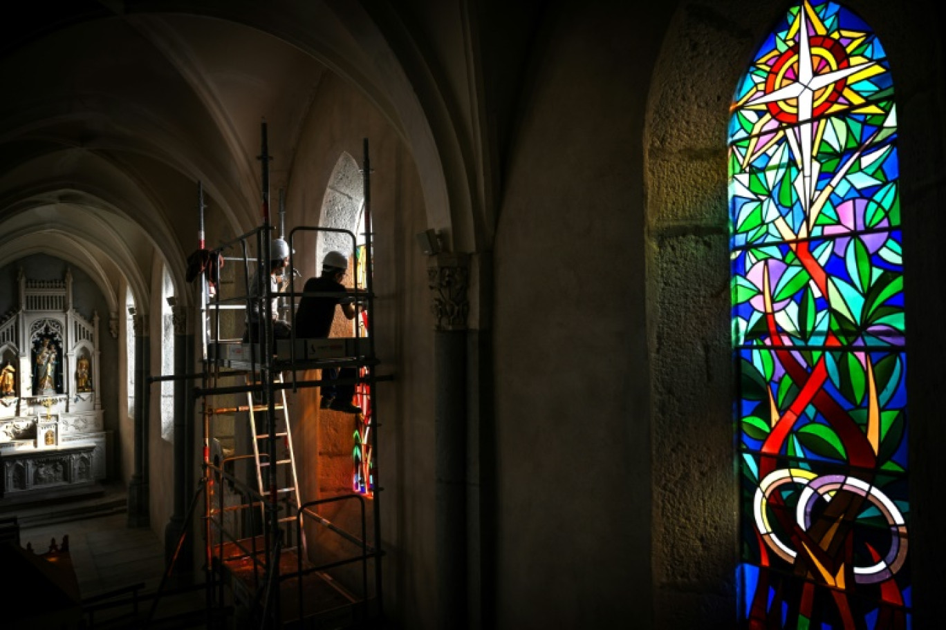 Des ouvriers retirent le vitrail intitulé "L'Enfant prodigue" conçu par le Père Ribes, le 24 octobre 2023 dans l'église de la commune Sainte-Catherine © Olivier CHASSIGNOLE