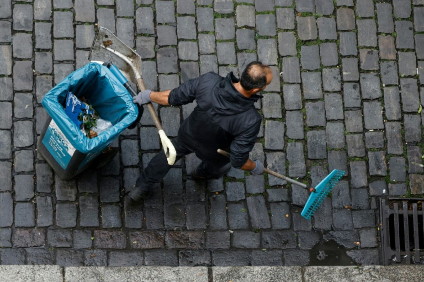 Un homme nettoie les rues à Berlin, le 28 juillet 2023 © David GANNON