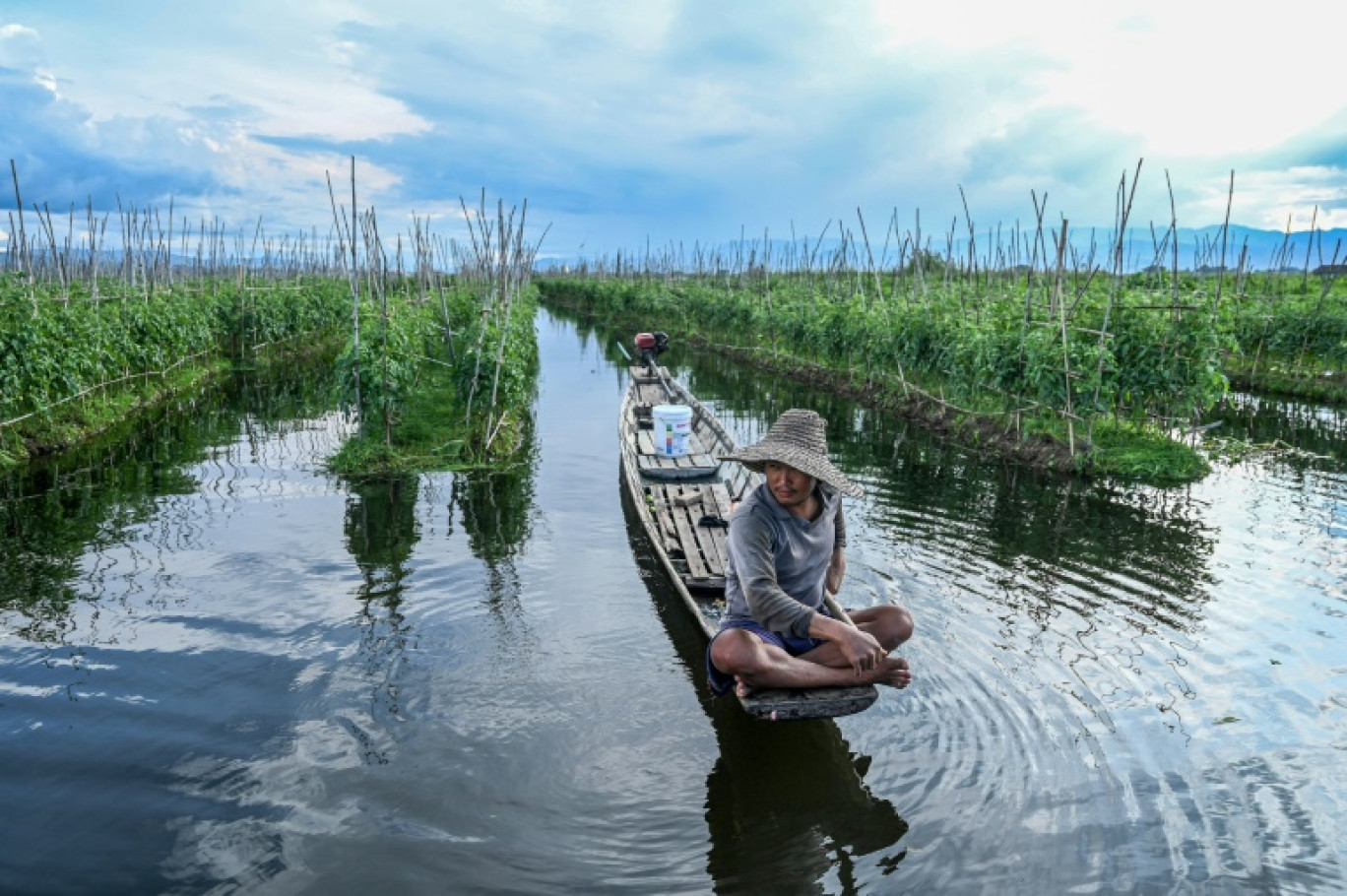 Un homme passe en bateau entre les rangées de sa ferme flottante sur le lac Inle, dans le sud de l'État Shan, le 17 octobre 2023 en Birmanie © SAI AUNG MAIN